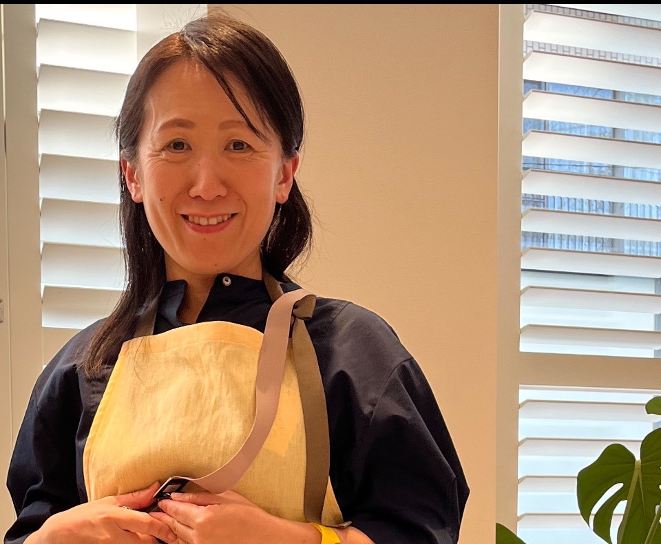 Akiko, your host, smiling in her kitchen apron