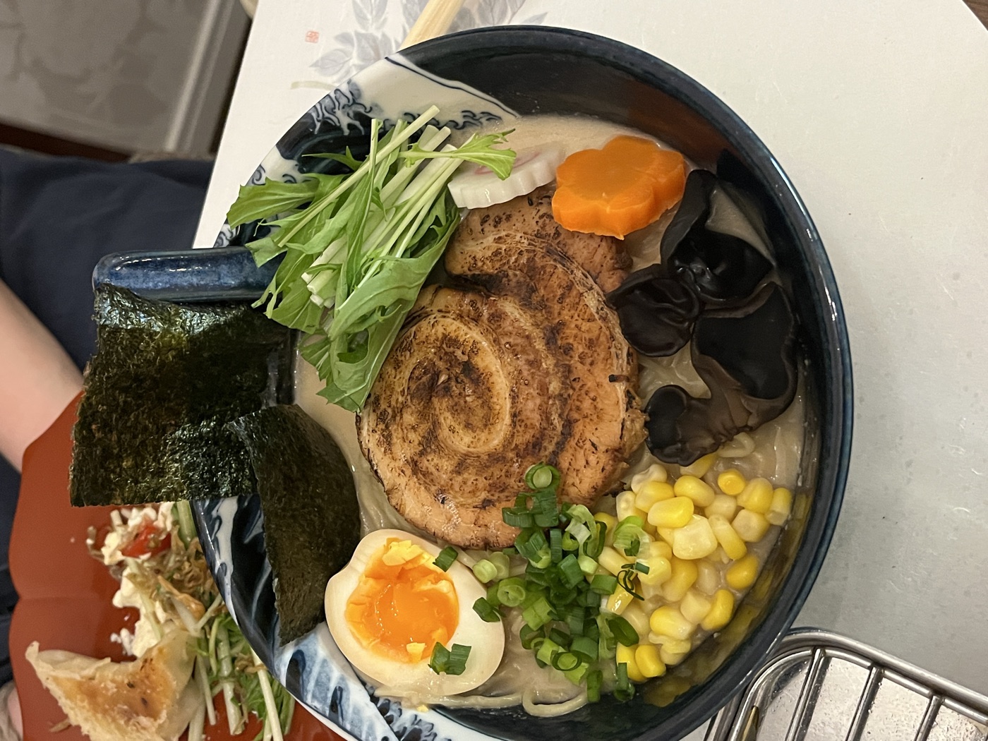 Your finished ramen bowl: torched chashu, soft-boiled egg, corn, mizuna and kikurage mushrooms