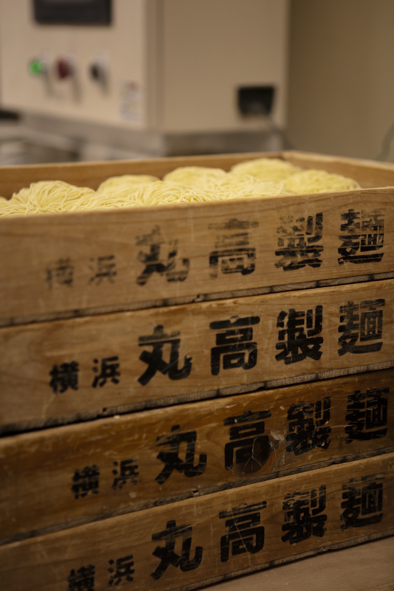 Stacked wooden Marutaka Seimen boxes filled with freshly cut ramen noodles