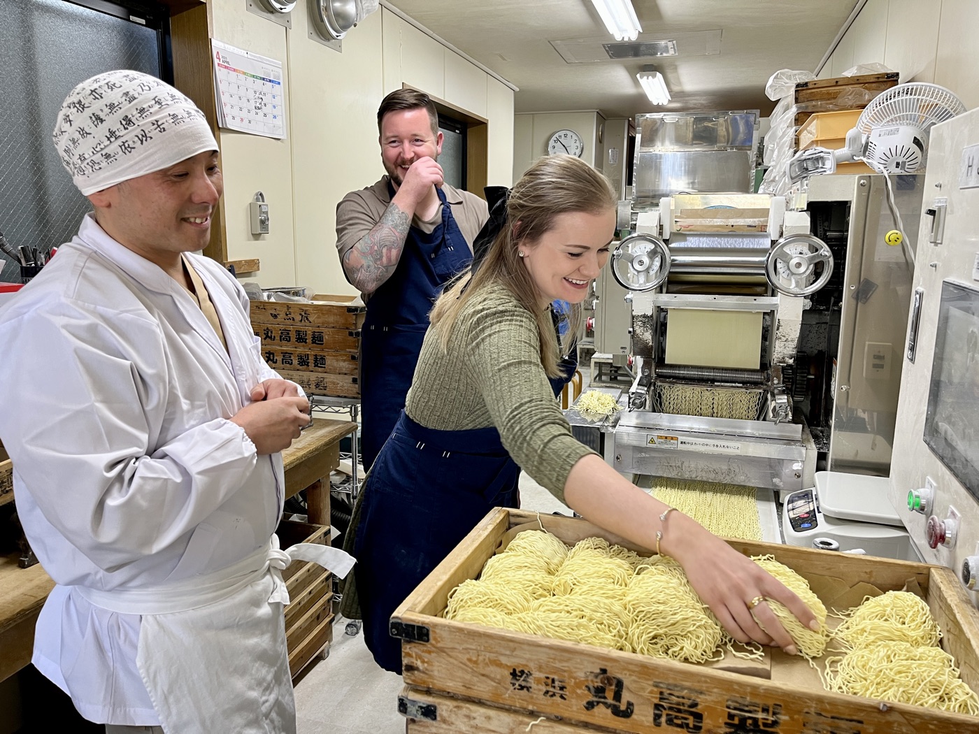 Taka and guests gathering fresh noodles from the cutting machine into a wooden box