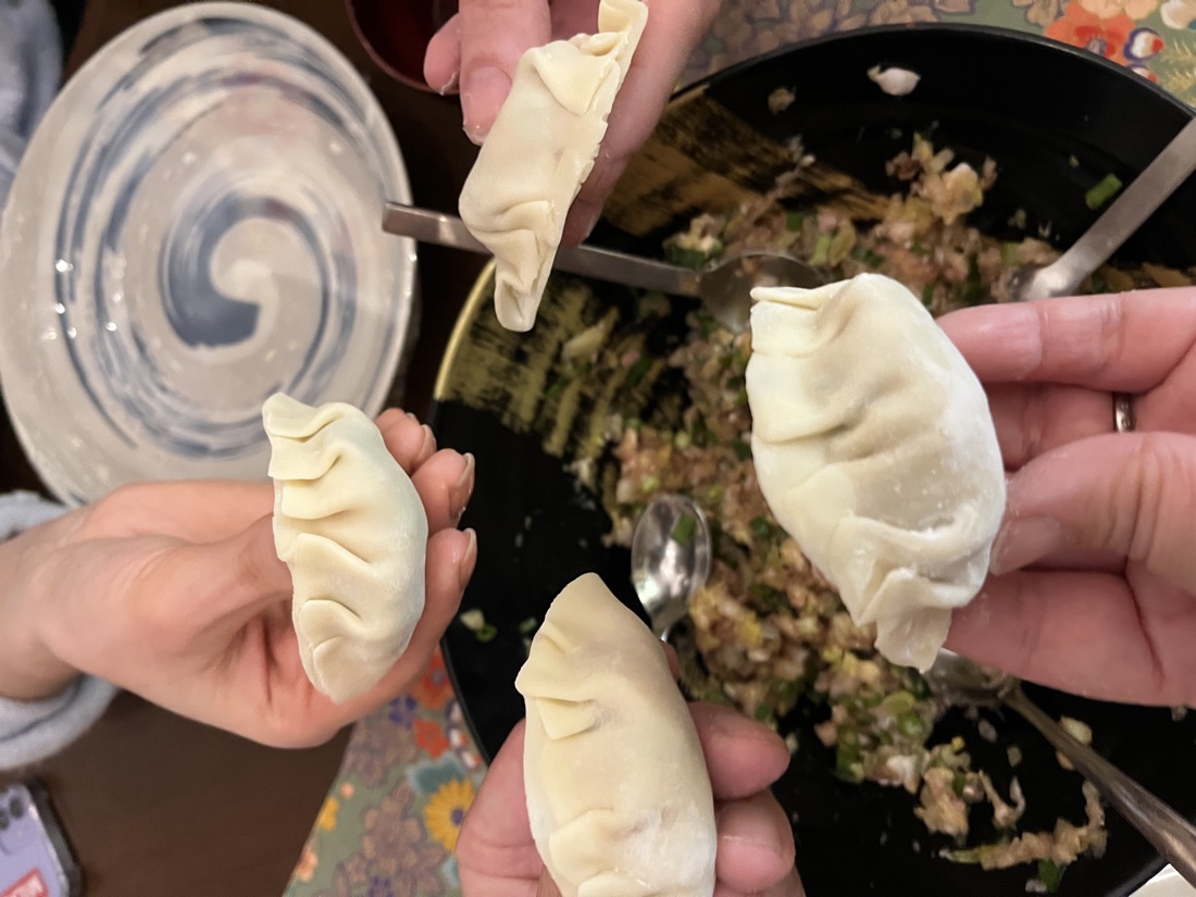Guests holding up the gyoza they just folded