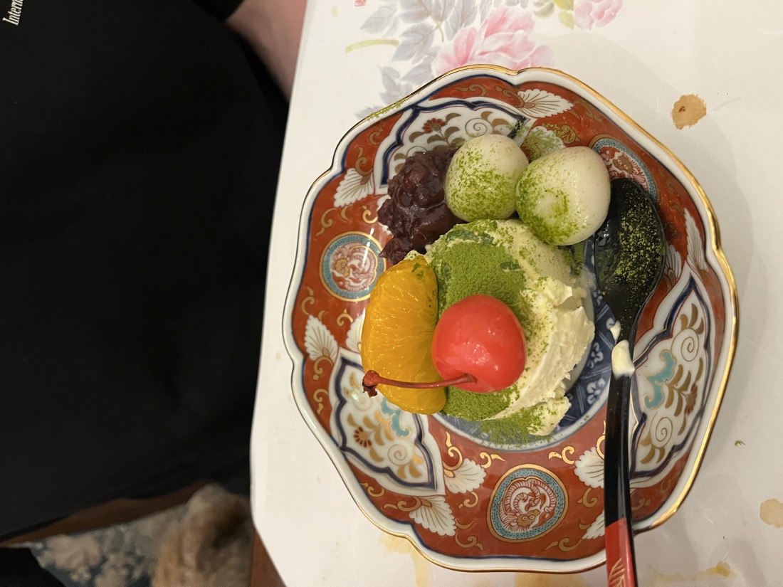 Matcha dessert with red bean, dango and fruit in a beautiful painted bowl